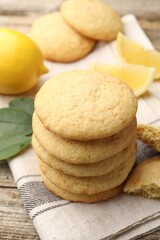 Tasty lemon cookies and fruit slices on wooden table, closeup