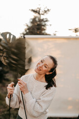 Dunkelhaarige Frau mit Palmenbl&auml;ttern vor Studiohintergrund in freier Natur