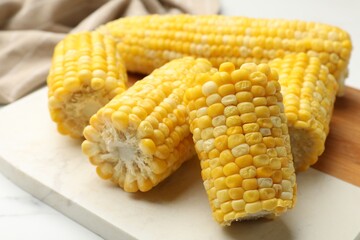 Pieces of boiled corncobs on white table, closeup