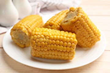 Pieces of boiled corncobs on light wooden table, closeup