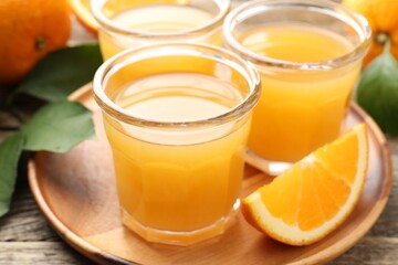 Fresh orange juice and fruits on wooden table, closeup