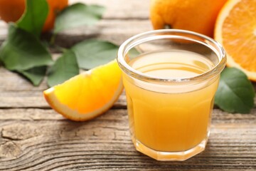 Fresh orange juice and fruits on wooden table, closeup