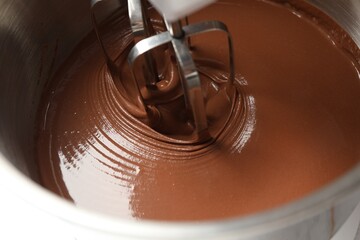 Mixing chocolate dough in bowl, closeup view