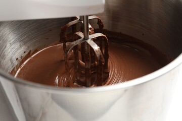 Mixing chocolate dough in bowl, closeup view