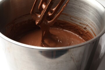 Mixing chocolate dough in bowl, closeup view