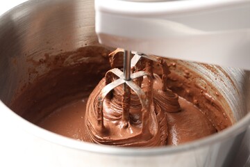 Mixing chocolate dough in bowl, closeup view