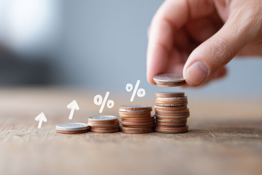 A hand is holding a stack of pennies with a drawing of a graph showing the penni