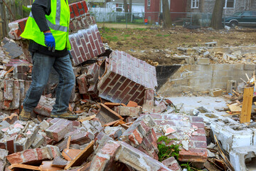 Construction worker removes debris from demolished building site in residential