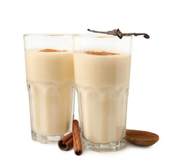 Delicious protein shake in glasses, cinnamon and vanilla pods isolated on white