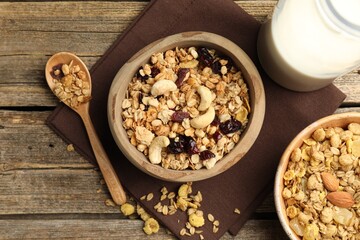 Tasty granola with dried fruits, nuts and milk on wooden table, flat lay