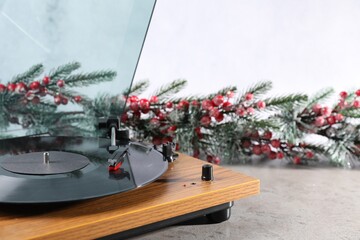 Turntable with vinyl record and Christmas decor on light table, closeup. Space for text