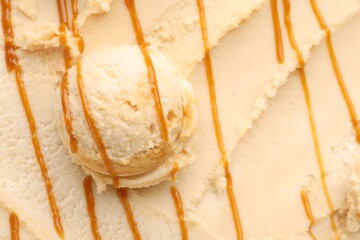 Tasty ice cream with caramel sauce as background, top view