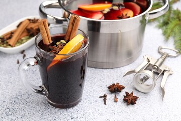 Traditional mulled wine, corkscrew and spices on light grey table