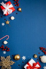 Red and white Christmas decorations and gifts on blue background.