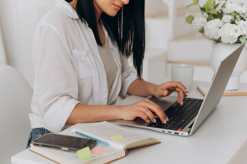 Joyful female worker, Happy woman using laptop, Female professional calmly balancing tasks with smile, Content woman happily handling personal and professional responsibilities at her workspace