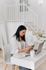 Woman organizing media content calmly, Confident woman planning digital posts in cozy studio environment, Female freelancer reviewing and scheduling social media posts comfortably with coffee nearby