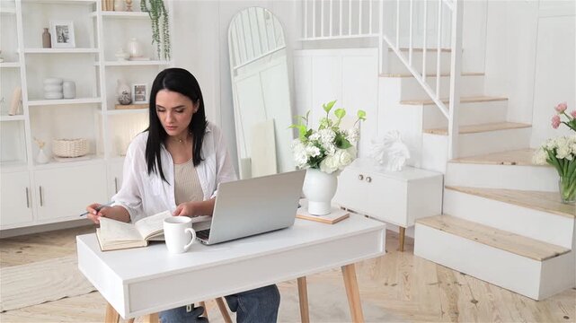 Woman planning workspace, Caucasian female organizing notes, Female freelancer engaged in focused scheduling at desk, Calm morning scene featuring woman arranging plans with coffee and flowers