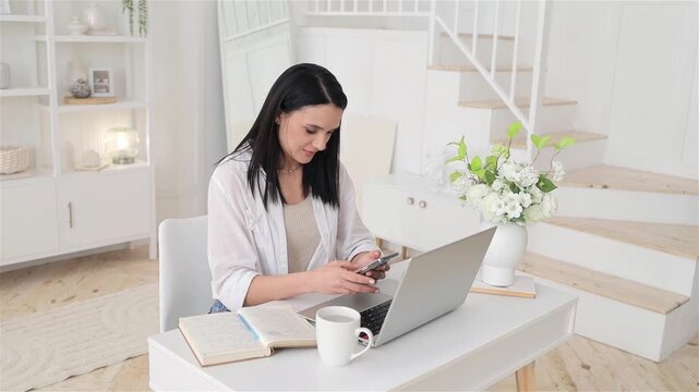Woman rests casually, Relaxed lady takes quick break, Happy female on short rest at her workspace, Relaxed woman pauses to check her phone amidst her work tasks, Woman enjoys brief pause during work