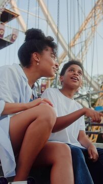 Big sister and little brother and pointing aside at funfair