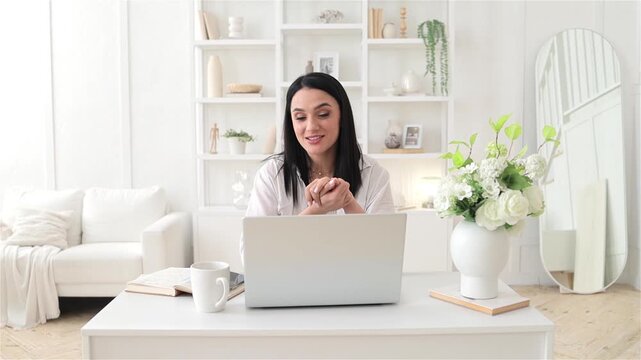 Confident woman enjoys her online session, Relaxed woman smiling during remote coaching session, Casual confident woman happily engaging in virtual coaching within cozy modern home setting