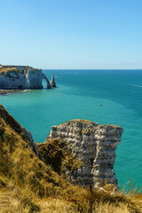 Great view of Stone cliffs and large rocks against the backdrop of ocean water in the Etretat in Normandy, France The water and sky are blue and transparent The weather is clear