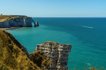 Great view of Stone cliffs and large rocks against the backdrop of ocean water in the Etretat in Normandy, France The water and sky are blue and transparent The weather is clear