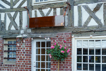 The building has three window boxes with flowers in them in France. The boxes are placed on the windows of the building, adding a touch of color and life to the brick exterior