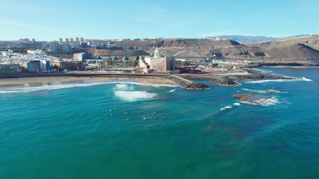 Aerial view of surfers at Las Canteras beach with the Alfredo Kraus Auditorium in the background. Las Palmas. Gran Canaria