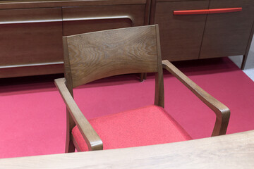 Wooden desk and chair with red seat on the red floor in the living room, close-up