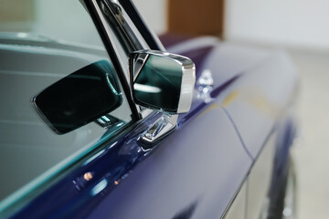 Side mirror and window close-up details of a blue vintage American Car. Side view of a classic car with copy space.