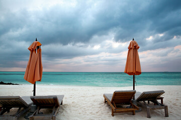 Beautiful Tropical Beach with Orange Umbrellas and Lounge Chairs
