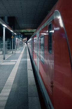 Standing by the train on a deserted train station at night