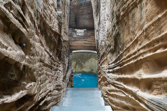 Navghan Kuvo, the ancient rock-cut stepwell in Uparkot Fort, Junagadh, India known for its deep, narrow stairway and historic architecture.	