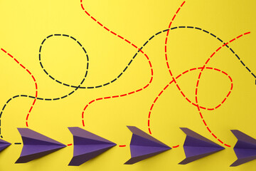 Paper planes with dotted lines as air route track on yellow background © New Africa