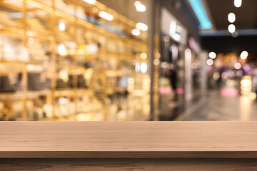 Empty wooden table against blurred view of shopping mall. Space for design