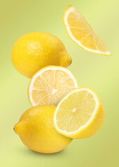 Fresh lemons falling on pale olive color background