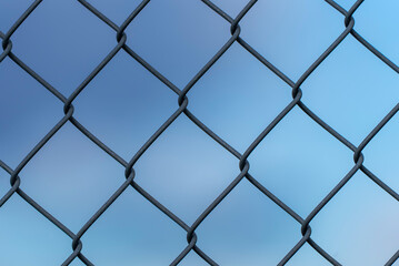Fototapeta premium Close up of a chain link metal fence with blue sky background