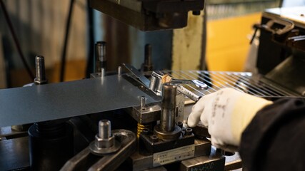 Close Up of Skilled Factory Worker Using Specialized Tool on Press Machine in Metal Manufacturing