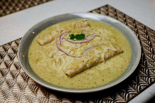 Enchiladas verdes con cebola encima