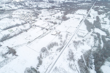 Obraz premium Aerial View of a Small Village and Train Tracks in Winter Snow The Concept of Rural LivinG