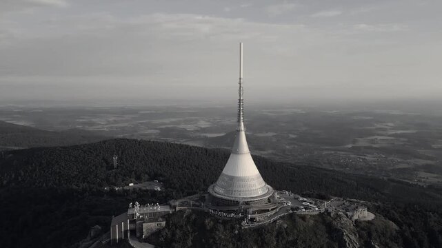 Watch as the sun sets over Jested Mountain in Liberec, revealing breathtaking aerial views of the hotel and iconic TV transmitter. Experience the beauty of Czechia's landscape.