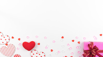 Romantic Valentines Day Background with copy space and red and white hearts, small beads, knitted heart, and gift box.