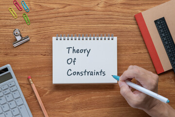 There is notebook with the word Theory Of Constraints. It is as an eye-catching image.