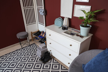 Interior of hallway with shoe stand, commode and folding screen
