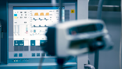 Medical monitoring equipment displaying vital signs and data on a digital screen, showcasing advanced technology in a clinical environment with focus on healthcare innovation