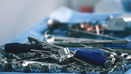 Collection of various metallic tools and equipment arranged on a blue surface, showcasing intricate details and textures, ideal for repair and maintenance projects
