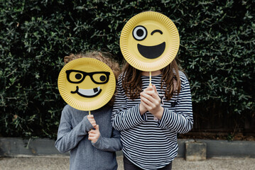 Anonymous children holding handmade happy emoji / emoticon masks; Melbourne Australia.