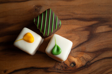 An elegant arrangement of artisan white chocolate squares, beautifully decorated and presented on a rustic wooden board. Perfect for gifts and celebrations.