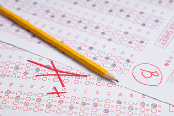 Pencil and answer sheets form of school test with results, closeup