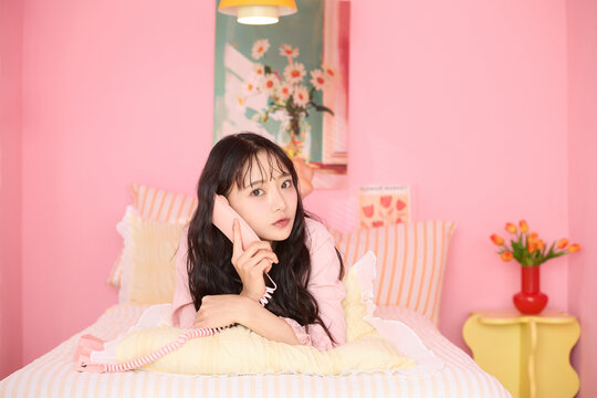 カラフルなベッドレームでリラックスする若い女性のかわいいポートレート